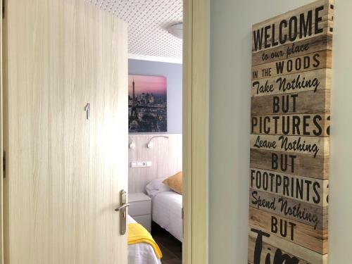 a bedroom with a door with a welcome to our house in the woods but pictures at Alojamiento HC in Colmenar Viejo