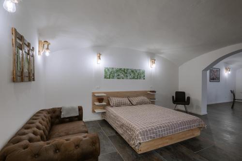 a bedroom with a bed and a couch at Maneki Serra 1/2D in Bologna