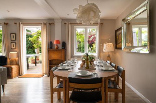 a dining room with a table and chairs and windows at Lewes Heights is a spacious modern luxury home with stunning views in Lewes