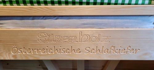 a wooden bench with a sign that reads sister doll intermediate subscriber at Schitterhof CHALETS in Spielberg