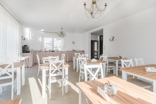 uma sala de jantar com mesas brancas e cadeiras brancas em Villa Lima em Ustka