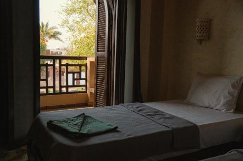 een slaapkamer met een bed en een raam met uitzicht bij Alf Leila Boutique Hotel in Dahab