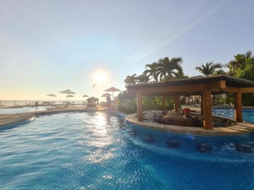 uma piscina de resort com o oceano ao fundo em Lujoso Departamento en Acapulco con Alberca y club de Playa em Acapulco