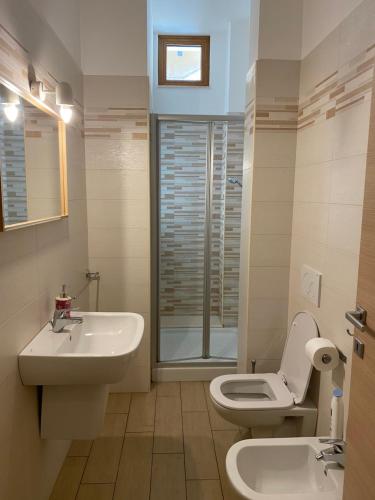 La salle de bains est pourvue d'un lavabo, de toilettes et d'une fenêtre. dans l'établissement Central Station Suite Apartment, à Bari