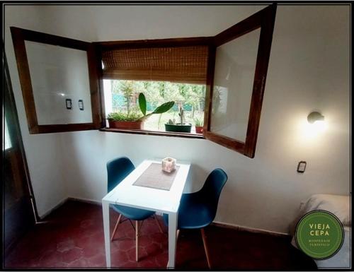 Habitación con mesa, 2 sillas y ventana en Vieja Cepa Departamento en San Rafael