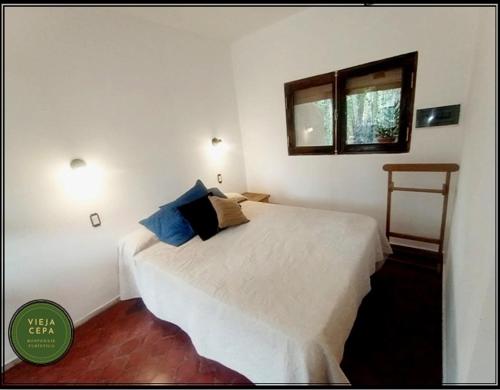 1 dormitorio con cama blanca y ventana en Vieja Cepa Departamento en San Rafael