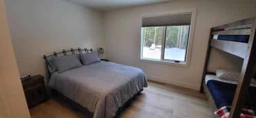 1 dormitorio con cama y ventana en Fernie Escape - Mountain Home on the Ski Hill, en Fernie