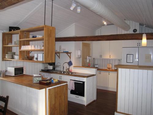 cocina grande con paredes blancas y suelo de madera en Hotell Ramudden en Gävle