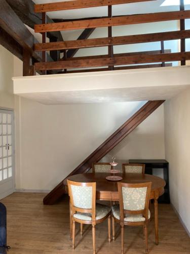 une salle à manger avec une table et des chaises en bois dans l'établissement Toulouse centre: T2 bis dans immeuble historique, à Toulouse