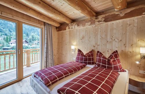 uma cama num quarto com uma grande janela em Haus im Giessen em Oetz