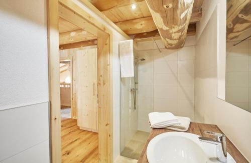 uma casa de banho com um lavatório e um tecto em madeira em Haus im Giessen em Oetz