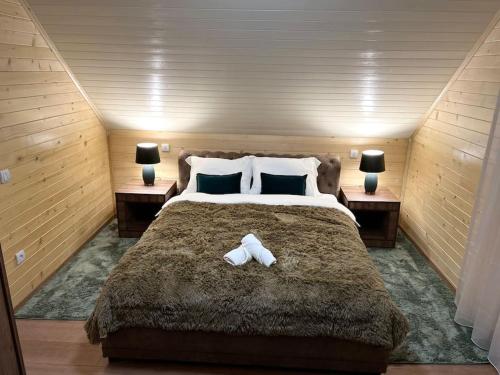 1 dormitorio con 1 cama grande y 2 mesitas de noche en Golden Eagle Jelovica en Berane