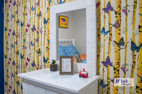 einen Spiegel in einem Zimmer mit Schmetterlingen an der Wand in der Unterkunft D´ Yoko Village´s in Pedernales