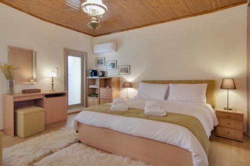 a bedroom with a large bed with two towels on it at Casa Margarita cozy & peaceful stay in Tzoumerka in Ioannina