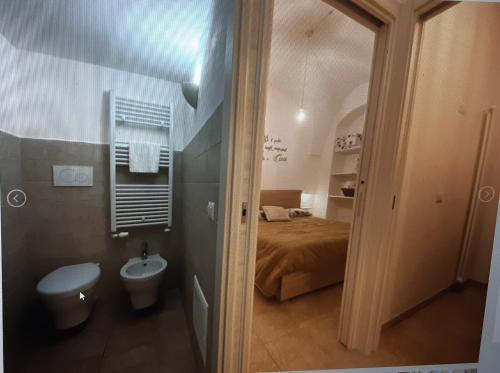 a small bathroom with a bed and a toilet at Eusebio's House in Cisternino