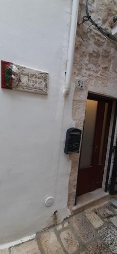 a sign on the side of a building with a door at Eusebio's House in Cisternino