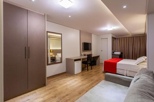 ein Schlafzimmer mit einem Bett und einem Schreibtisch in einem Zimmer in der Unterkunft Hotel Farol da Ilha in Florianópolis