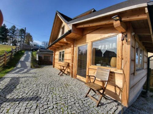 a wooden cabin with a chair in front of it at Wheelchair With Wings in Jaworzynka