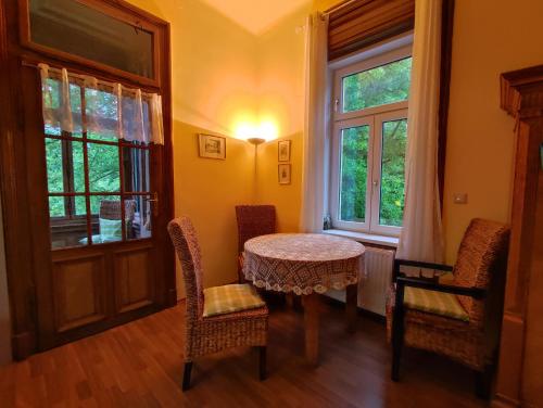 ein Esszimmer mit einem Tisch, Stühlen und einem Fenster in der Unterkunft Villa Petterhof in Schottwien