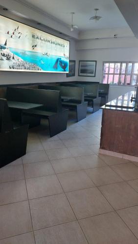 a waiting room with green tables and a large screen at Miras Del Mar in Puerto Madryn