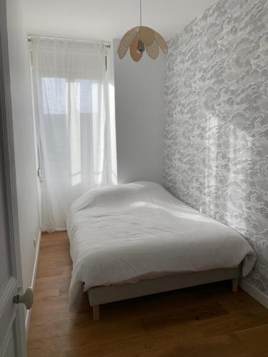 een kleine slaapkamer met een bed en een raam bij Champagne! Appartement spacieux Reims centre in Reims