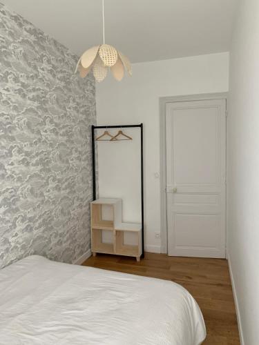 une chambre avec un lit et un miroir au mur dans l'établissement Champagne! Appartement spacieux Reims centre, à Reims