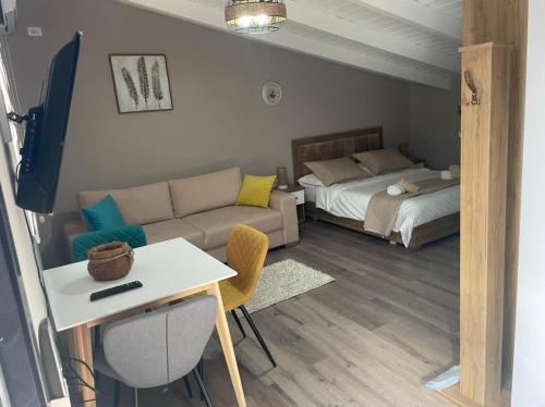 - un salon avec un canapé et un lit dans l'établissement Ora Apartament, à Pogradec