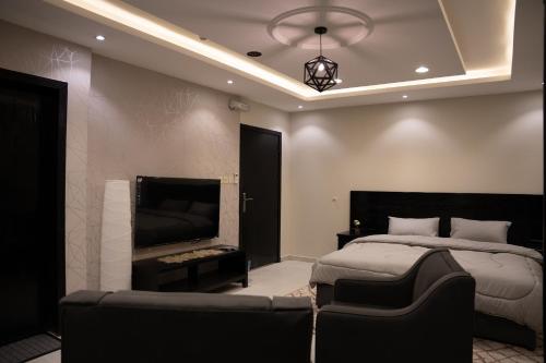 - une chambre avec un lit, un canapé et une cheminée dans l'établissement Fans Hotel Suites, à Abha
