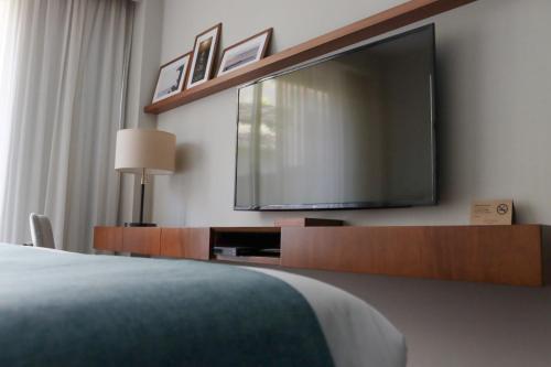 1 dormitorio con Tv LED grande en la pared en Cottage Puerto Buceo, en Montevideo