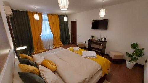 sypialnia z dużym łóżkiem i żółtym kocem w obiekcie Ambiennt w Bukareszcie