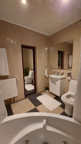 a bathroom with a tub and a toilet and a sink at Ambiennt in Bucharest