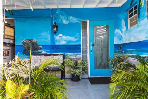 Shama's Guest House في كرايست تشيرش: باب امامي ازرق لبيت به نباتات