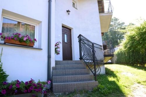 una casa con escaleras y una puerta y flores en Willa pod Zbójem Pipikasem, en Szczawnica