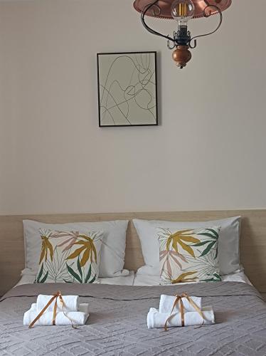 a bed with two towels and a picture on the wall at Villa Zdrojowa in Otmuchów