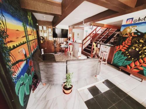 a room with paintings on the walls and a staircase at Divino Niño Hotel in Leticia