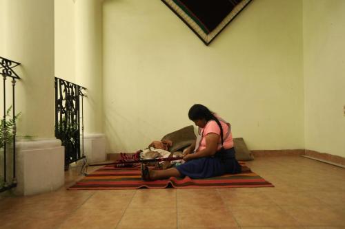 a woman sitting on the floor with a baby at Hostel Cultural Pata y Perro in Tarija