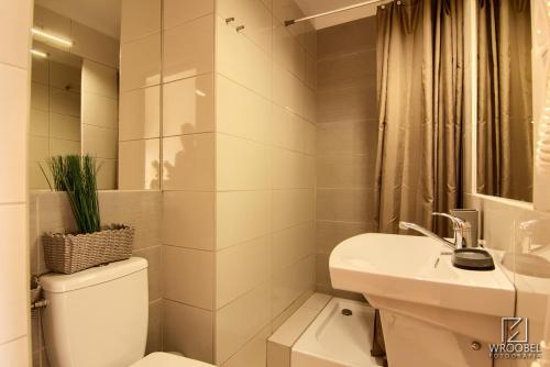 a white bathroom with a toilet and a sink at Noclegi u Gabrysi in Kościelisko