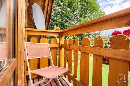 a chair sitting on a wooden fence with a surfboard at Noclegi u Gabrysi in Kościelisko
