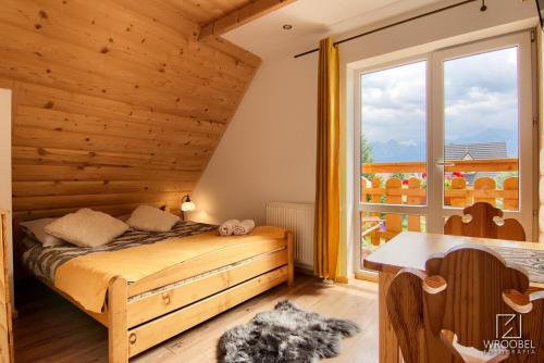 1 dormitorio con cama y ventana grande en Noclegi u Gabrysi en Kościelisko