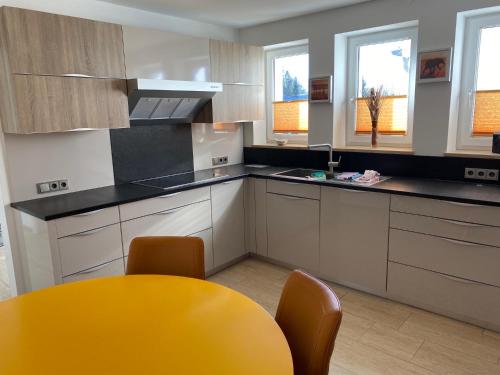una cocina con mesa amarilla y sillas. en Appartment Nocksteinblick, en Guggenthal