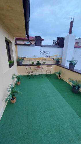 a balcony with chairs and a green carpet at Ambiennt in Bucharest