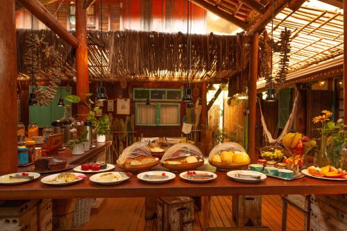 uma mesa com muitos pratos de comida em Pousada das Meninas na Ilha do Mel