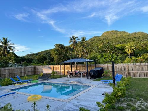 a backyard with a swimming pool with a table and a umbrella at Palm Tree Villas in Rarotonga