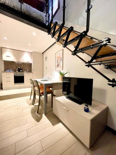 a kitchen and living room with a table and a tv at River Castle Central Verona in Verona