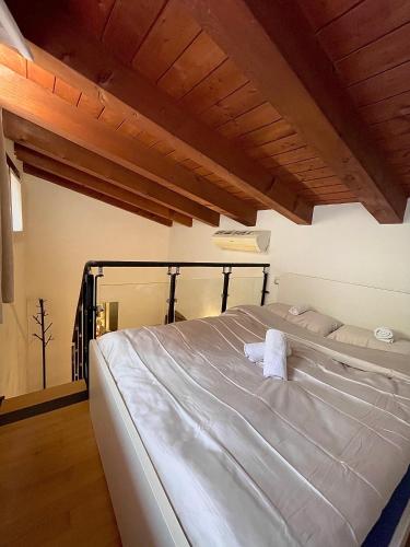 a large white bed in a room with wooden ceilings at River Castle Central Verona in Verona