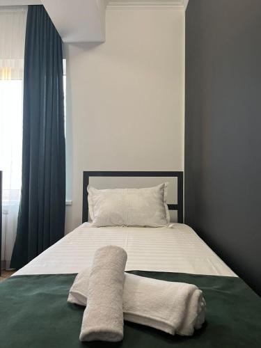 un lit avec deux oreillers dessus dans l'établissement A Hotel Bishkek, à Bishkek