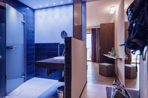 a bathroom with a shower with a sink in it at Familienresort Ellmauhof - das echte All Inclusive in Saalbach Hinterglemm
