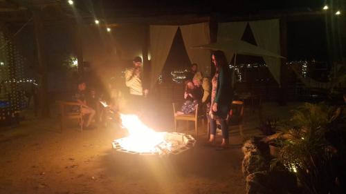 a group of people standing around a fire in a room at The FREE Hostel - Leisure Travel Only in Tulum