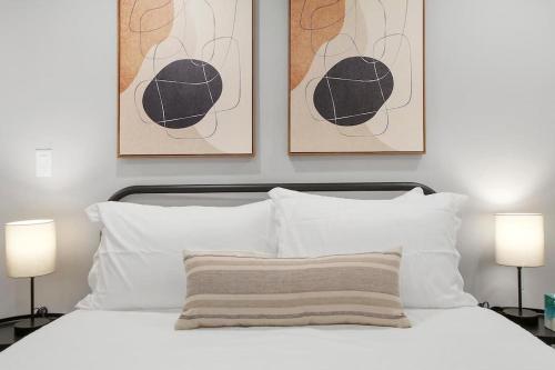 芝加哥的住宿－Chic 1BR Apartment With Modern Comforts - Barry GA，卧室配有一张墙上有两张照片的床。