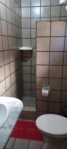 y baño con ducha, aseo y lavamanos. en Pousada Formosa, en Porto Seguro